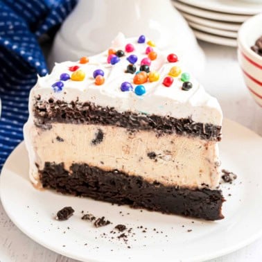 Slice of brownie cake with ice cream on a white plate.
