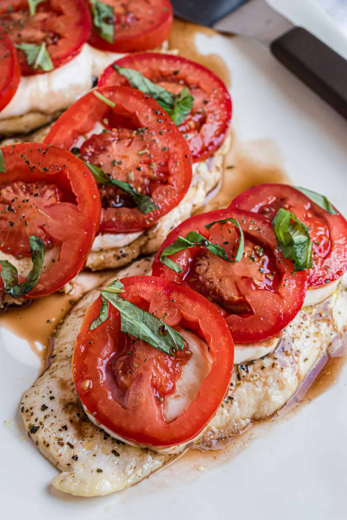 Chicken caprese on a white serving platter.