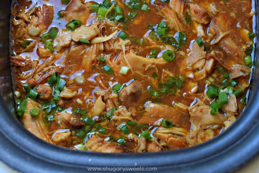 Bourbon chicken in slow cooker with green onions.