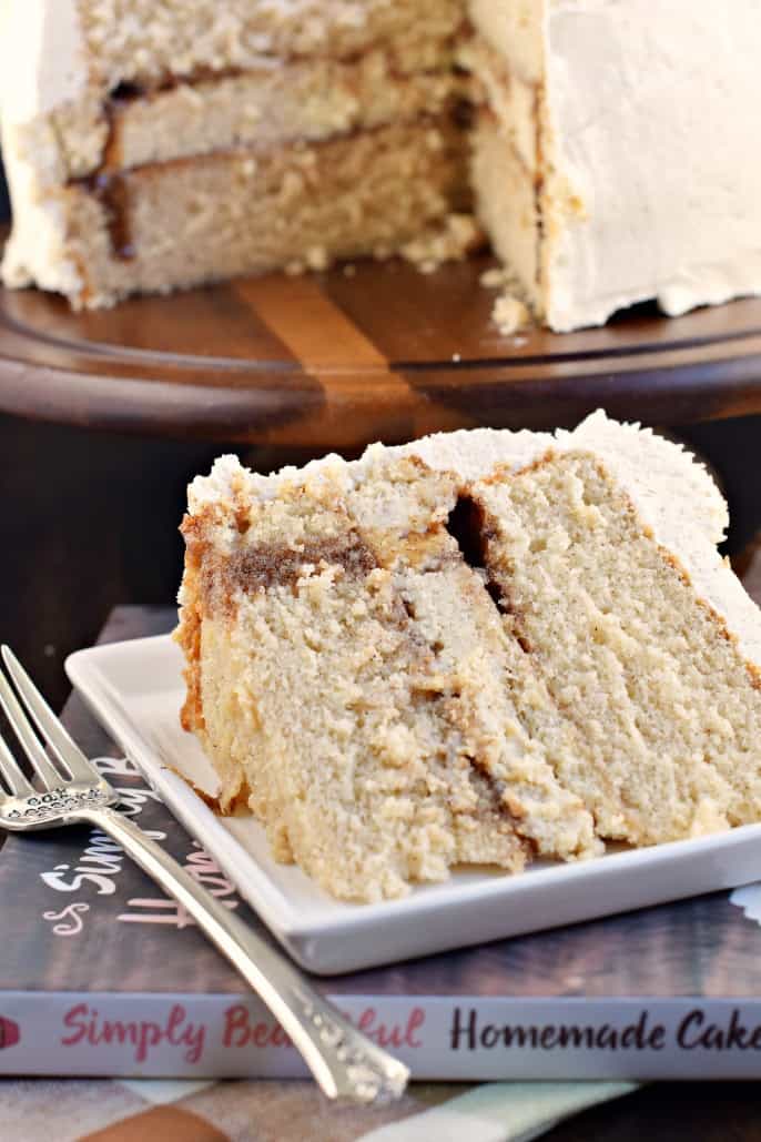 Slice of cinnamon cheesecake cake on a white plate.