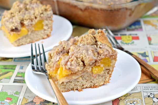 This delicious Peach Streusel Coffee Cake is a "must have" recipe for any time of year. Perfect, moist spice cake topped with peach pie and cinnamon streusel!