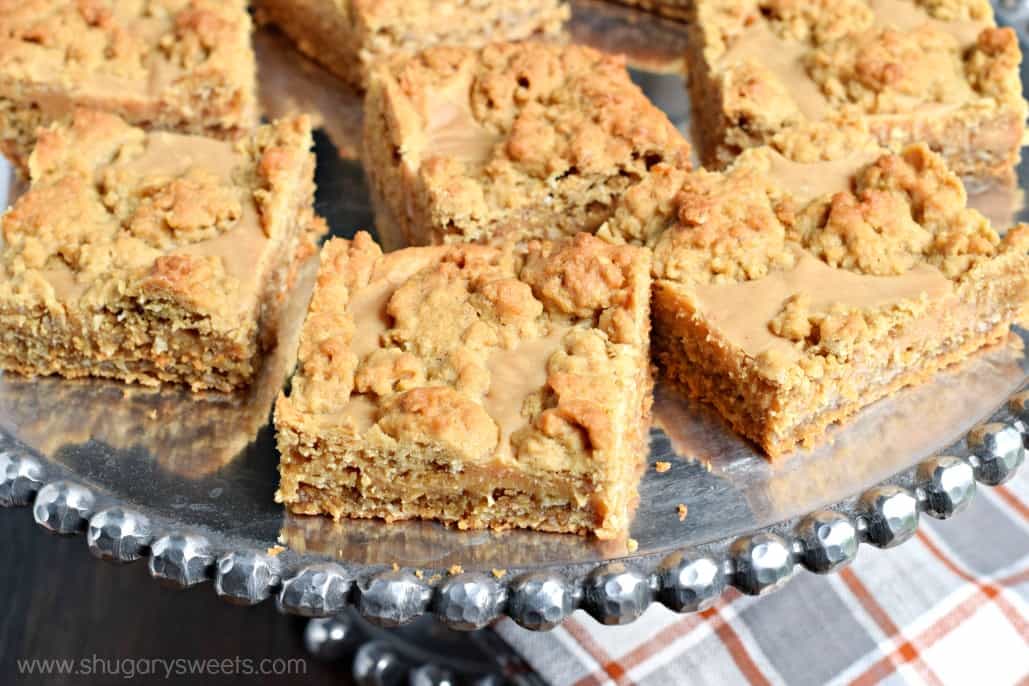 Oatmeal bars with peanut butter on a silver cake plate.