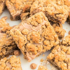 Oatmeal cookie bars with a crumbly topping and caramel chips, arranged closely together—perfect for fans of peanut butter revel bars.