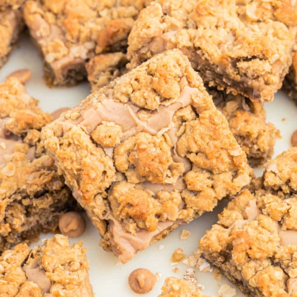 Oatmeal cookie bars with a crumbly topping and caramel chips, arranged closely together—perfect for fans of peanut butter revel bars.