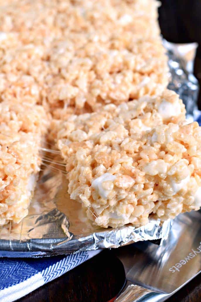 Classic rice krispie treat on a sheet of foil, being pulled from the pan so you can see the marshmallow.