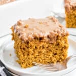 Slice of pumpkin cake on a white plate.