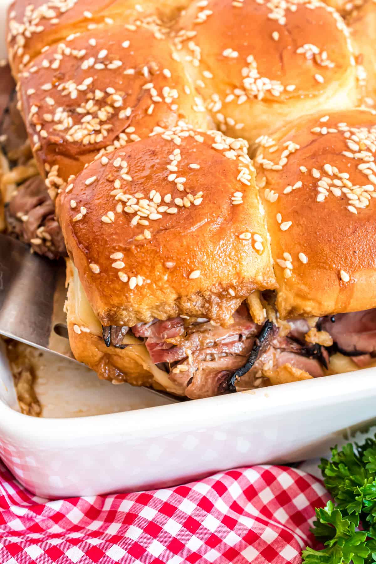French dip sliders baked in a white dish.