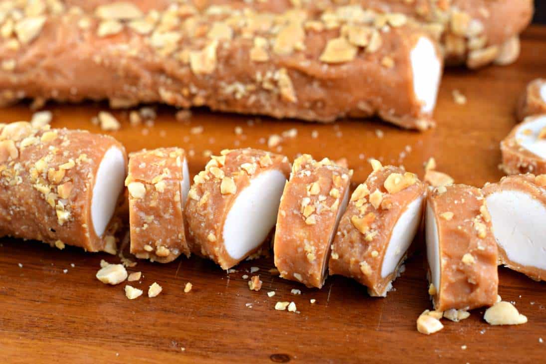 Salted nut roll on a wooden cutting board cut into slices.