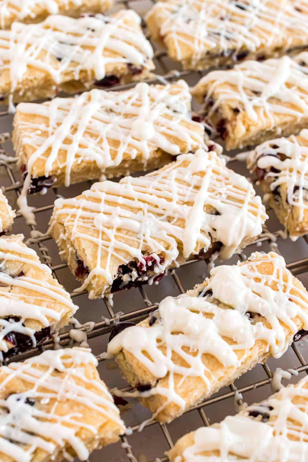 Cranberry white chocolate cookies cut into bars on a wire cooking rack.