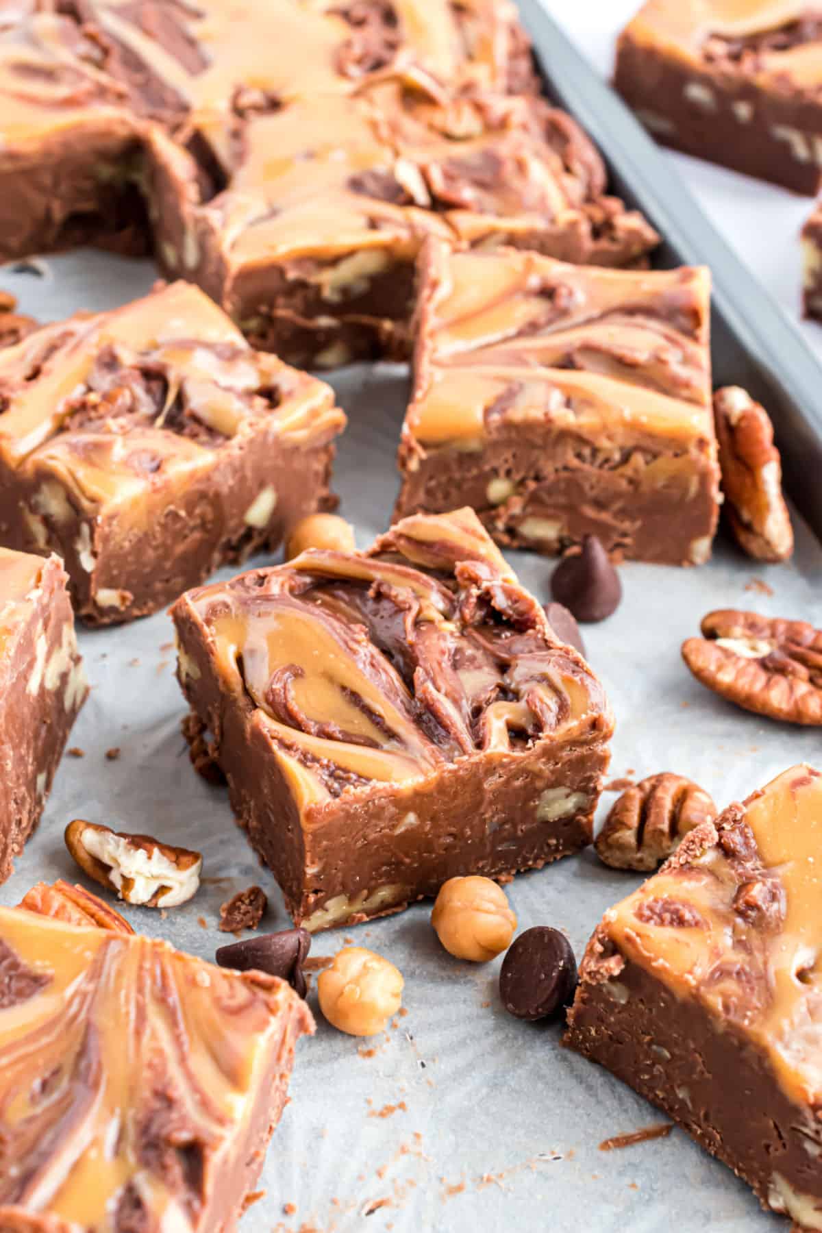 Chocolate fudge with nuts and caramel cut on parchment paper.
