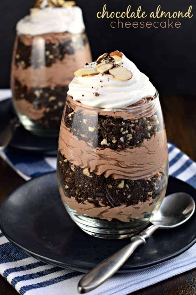 Stemless wine glasses with layers of cookie, almonds, and chocolate cheesecake.