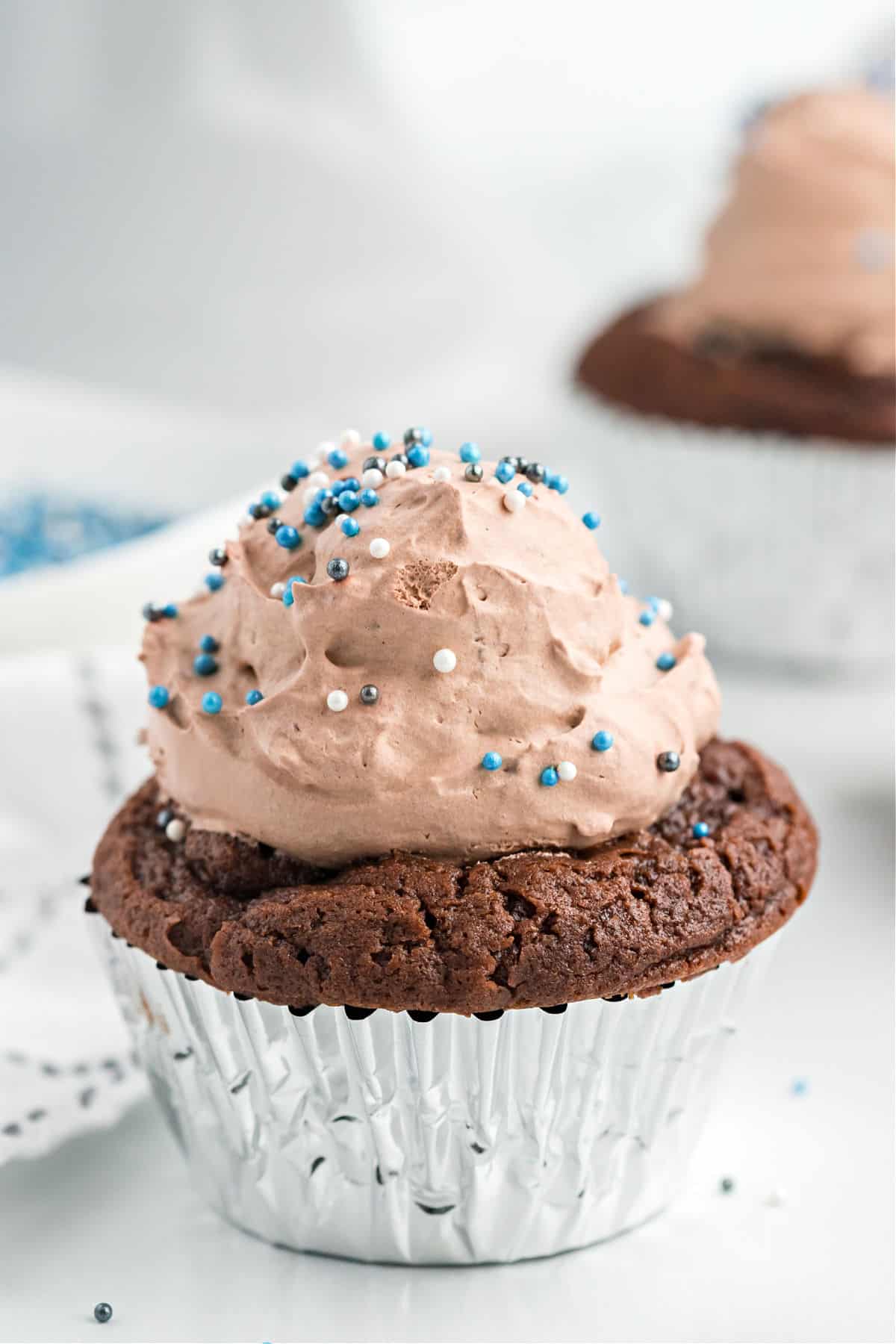 Chocolate cupcakes topped with pudding frosting and sprinkles.