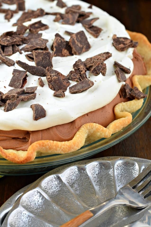 Chocolate pie with whipped cream and chocolate pieces.