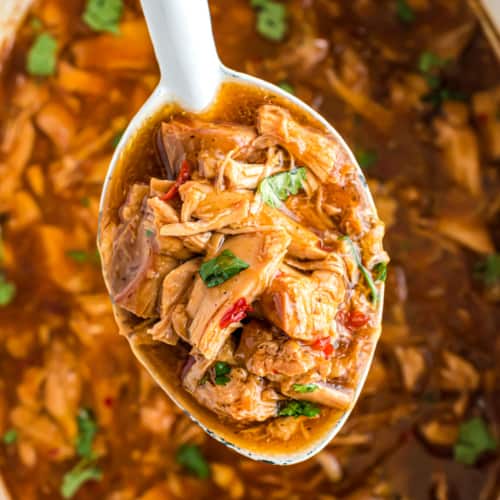 Sweet chicken chili in the slow cooker and a spoon.