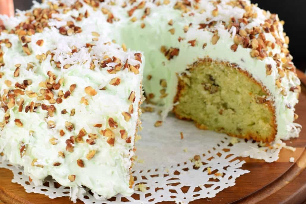 This Watergate Bundt Cake is nutty and moist thanks to pistachio pudding and pecans. Topped with a sweet, light whipped cream topping and coconut, this cake has it ALL!