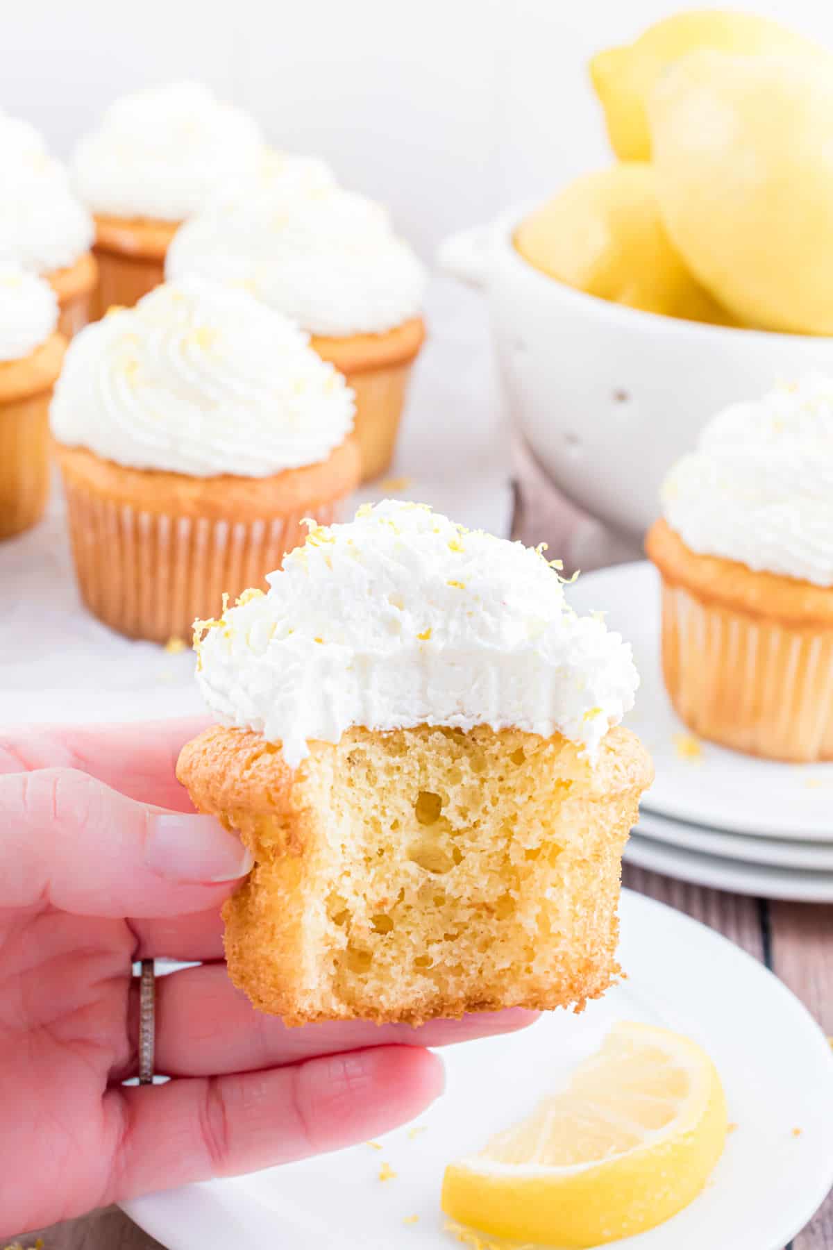 Lemon frosted cupcake with a bite taken out.