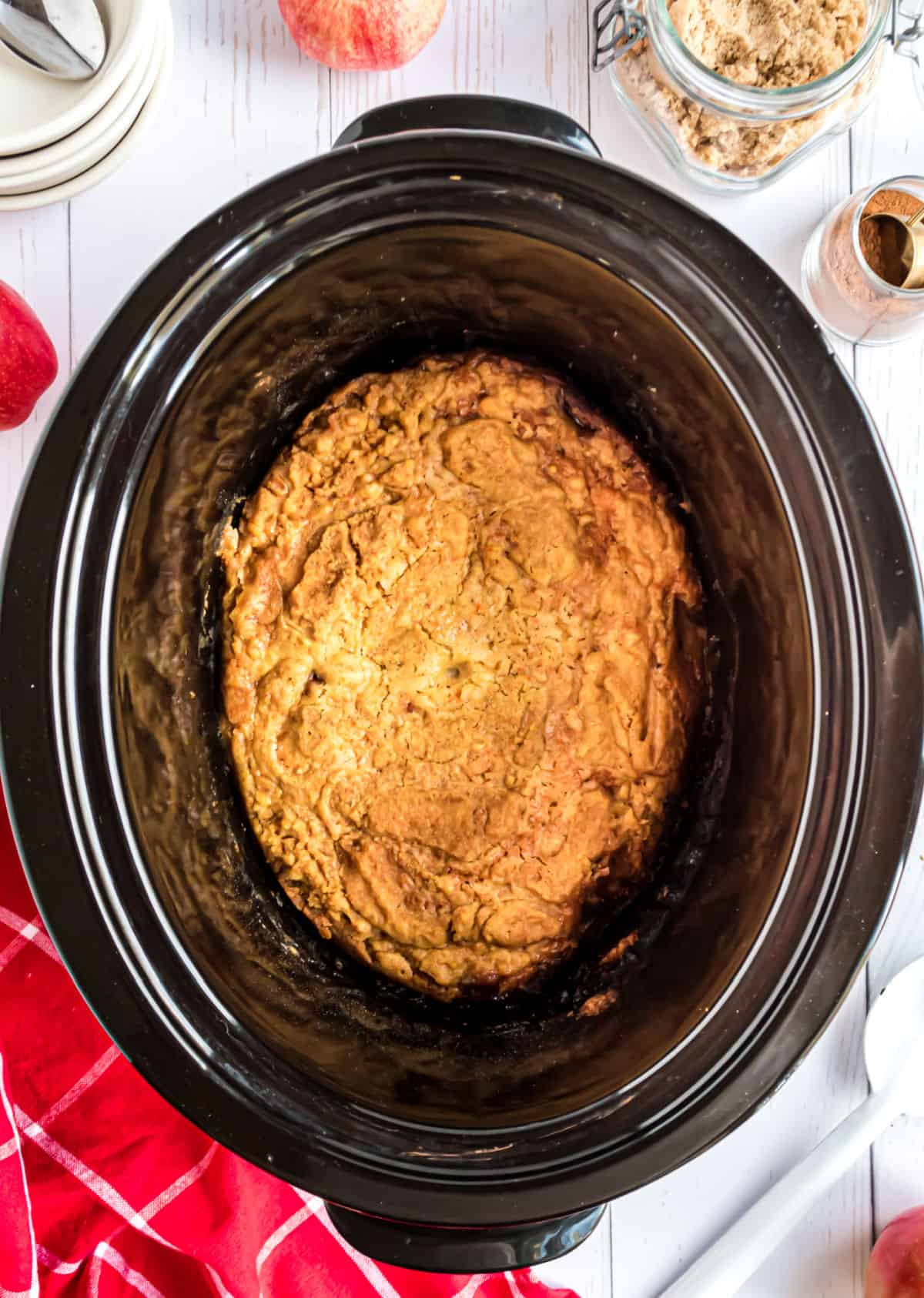 Slow cooker baked apple cake in a black crockpot.