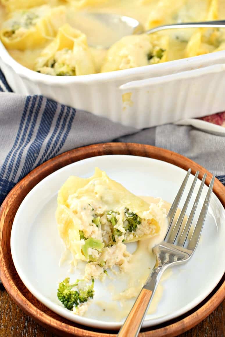 Alfredo chicken stuffed pasta shell served on a plate and cut in half.