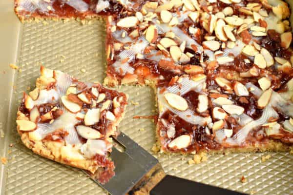 These Strawberry Almond Bars have a crunchy almond crust, chewy strawberry filling, and a creamy cheesecake topping. Perfect for holidays or weekend brunches!