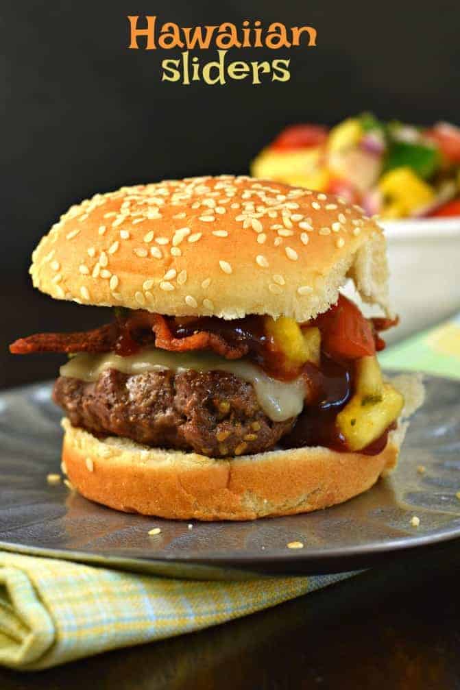 Burger on a bun with cheese, pineapple salsa, bacon, and bbq sauce.