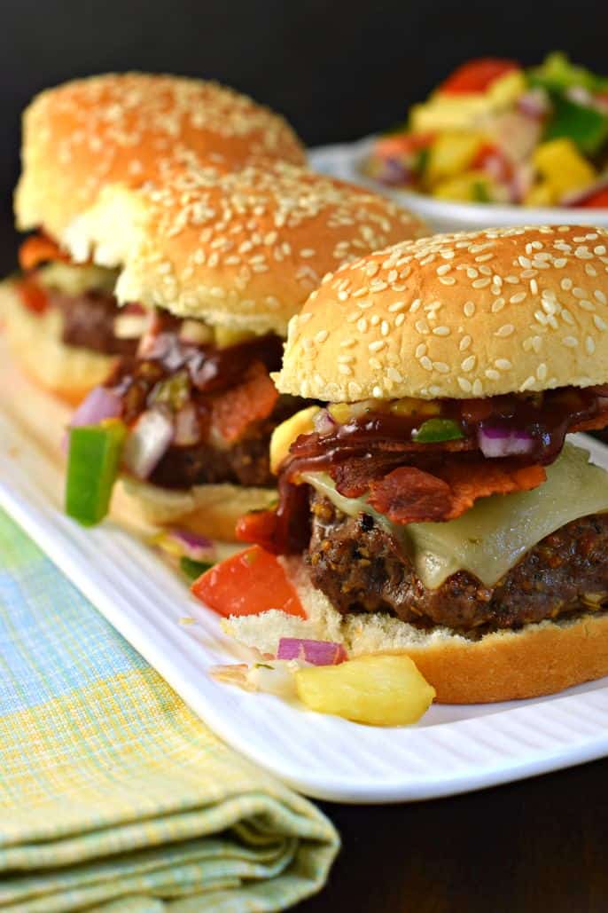 Trio of sliders on a plate and topped with bbq sauce.