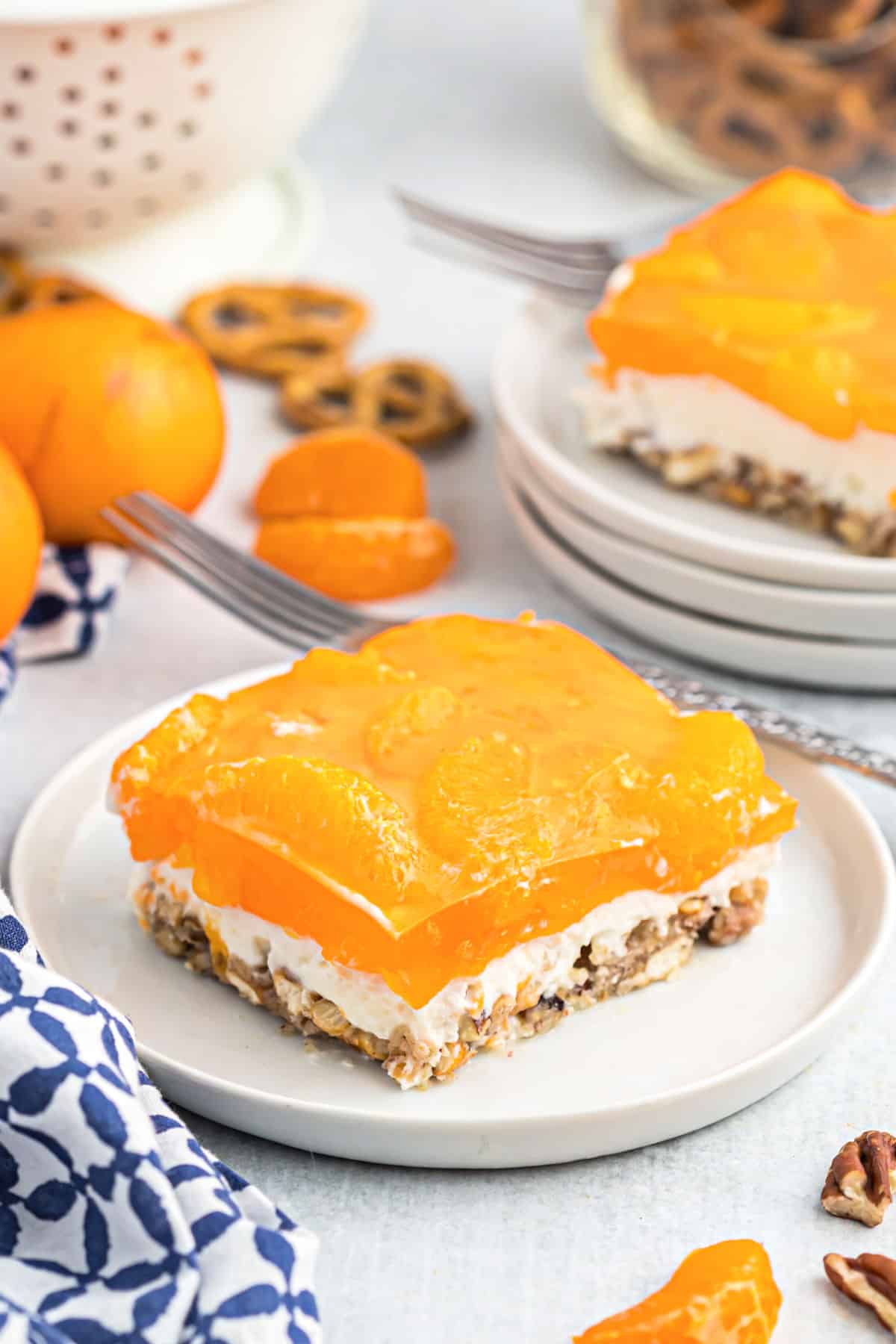 Slice of orange pretzel bar with cheesecake filling on a white plate.