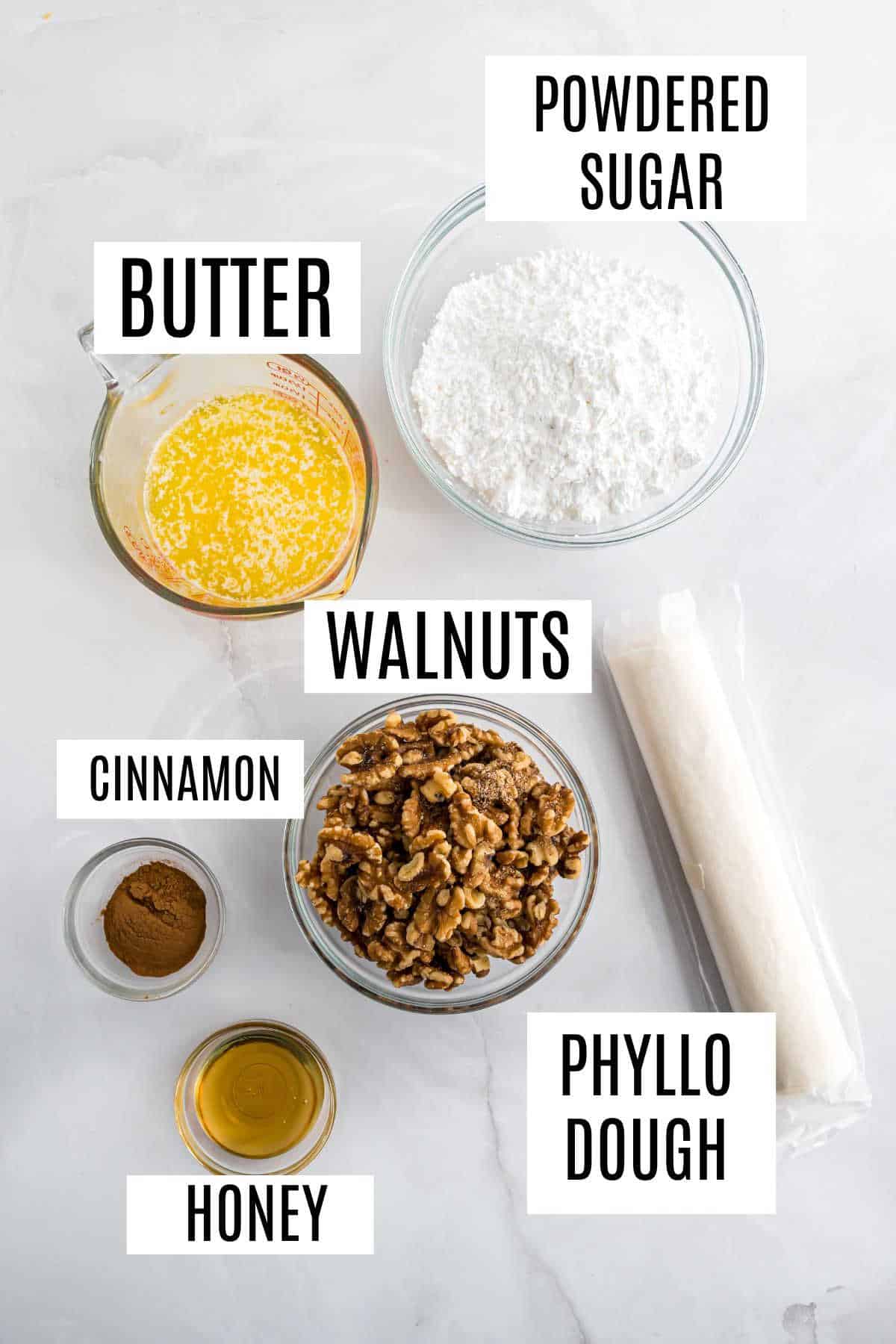 Top view of classic baklava ingredients: powdered sugar, butter, walnuts, cinnamon, honey, and phyllo dough—each labeled for perfect homemade baklava preparation.