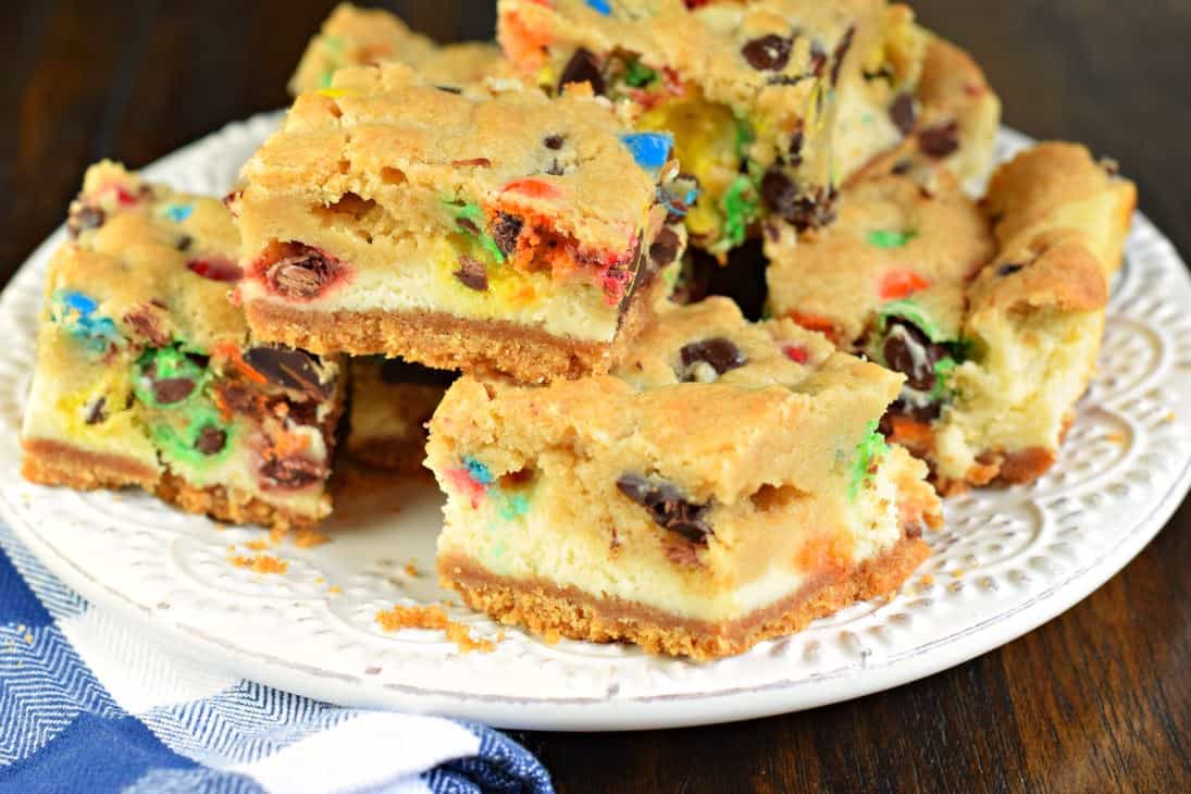 Stack of M&M cheesecake bars on a white plate.