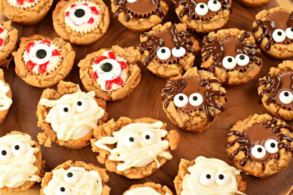 These Halloween Peanut Butter Cookie Cups start with a 3 ingredient, flourless cookie! Add your favorite candy and make a spooky treat this holiday!