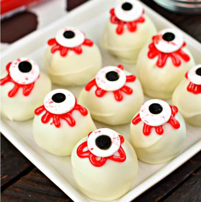 Red velvet cake balls decorated with red gel and candy eyes.