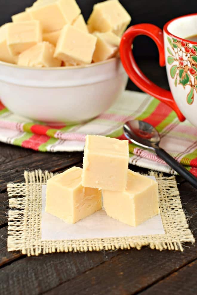 Stack of three pieces of butter rum fudge on parchment paper.