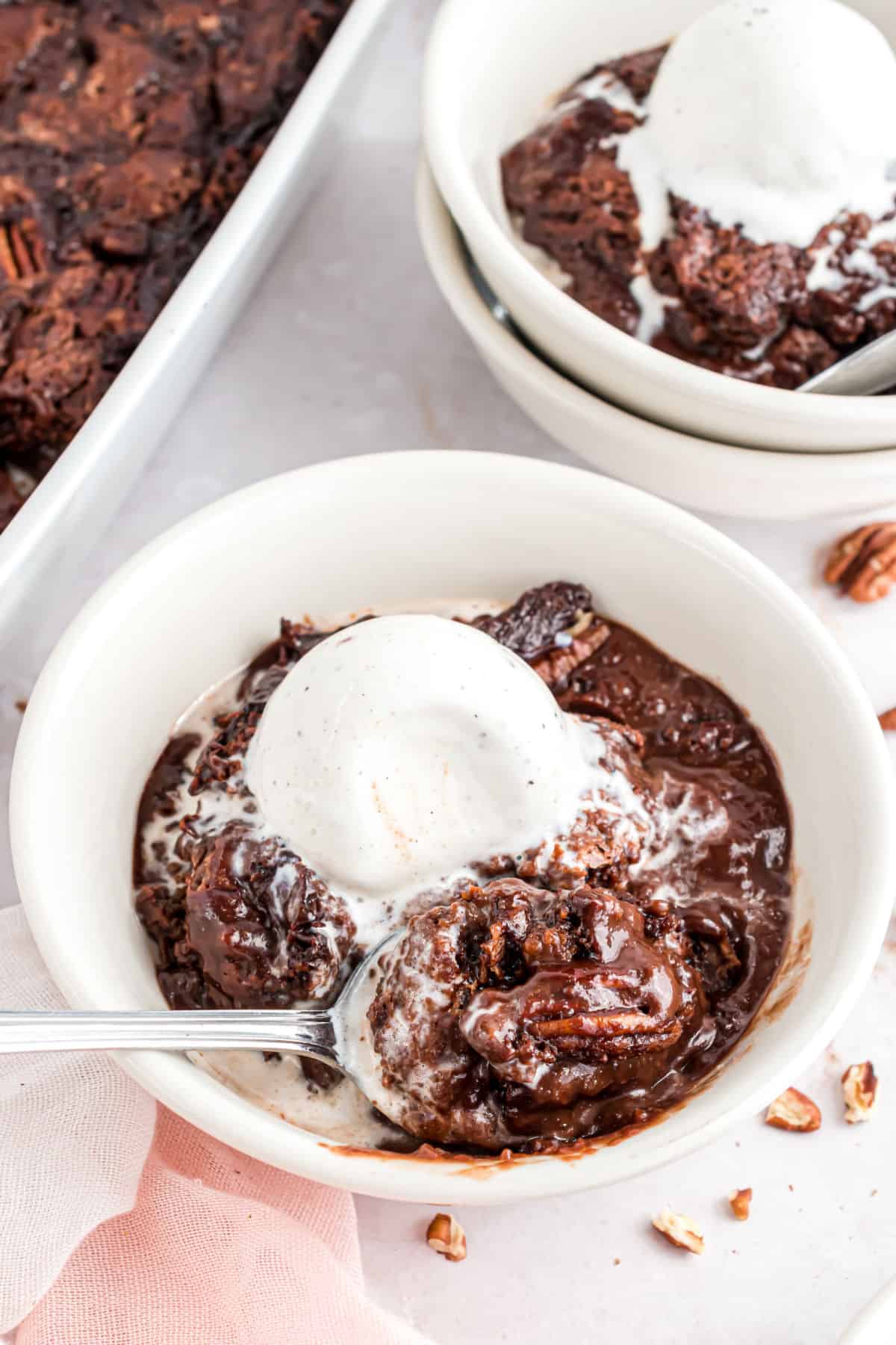 Chocolate cobbler in a bowl with melted vanilla ice cream.