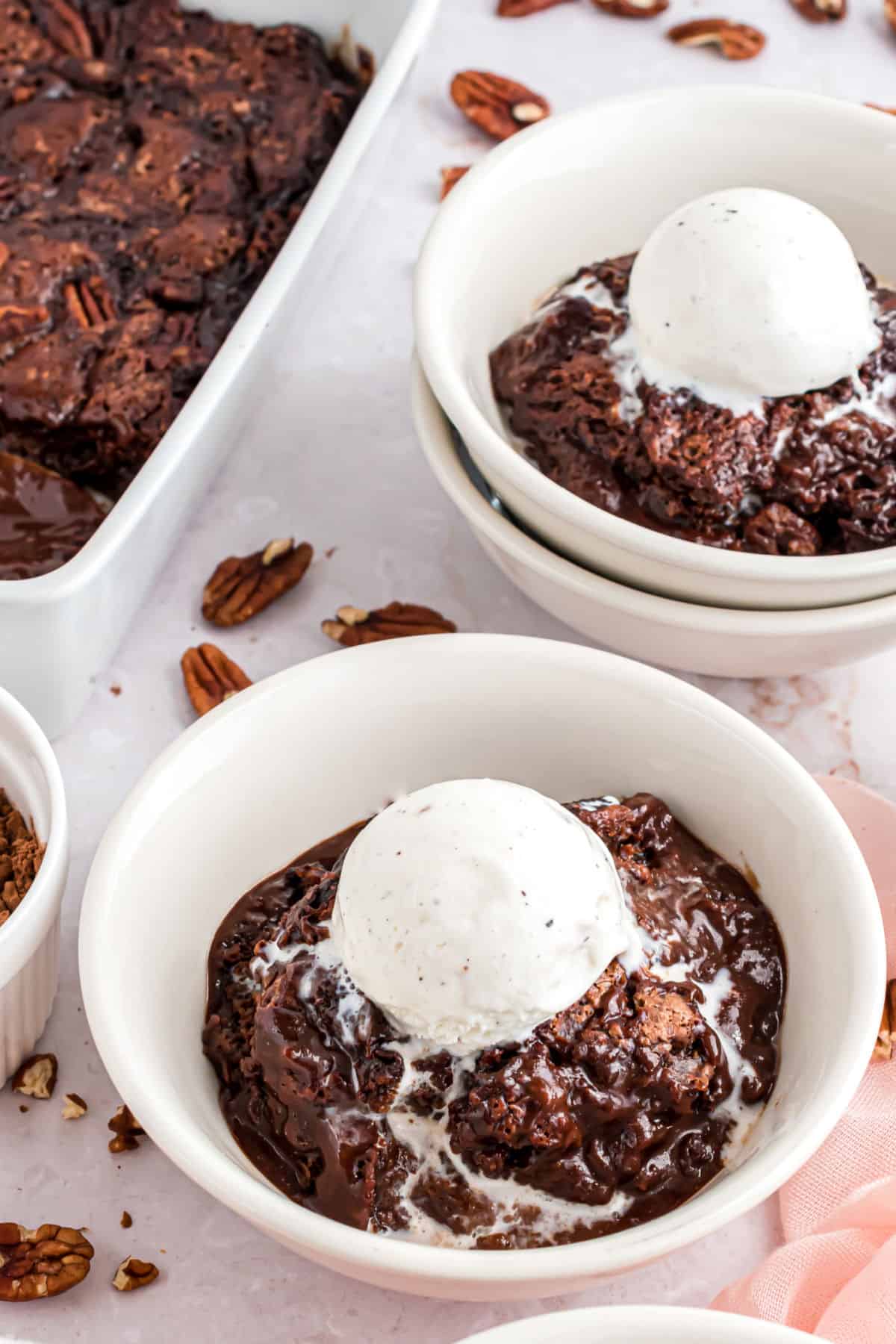 Chocolate cobbler with vanilla ice cream in a white bowl.