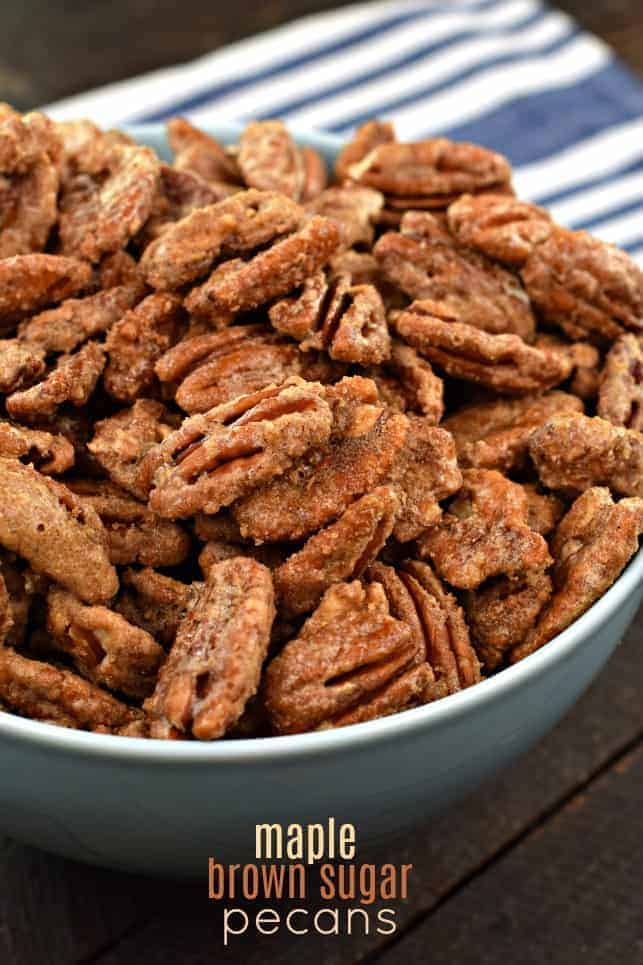 Maple Brown sugar candied pecans in a light blue bowl on a wooden surface.