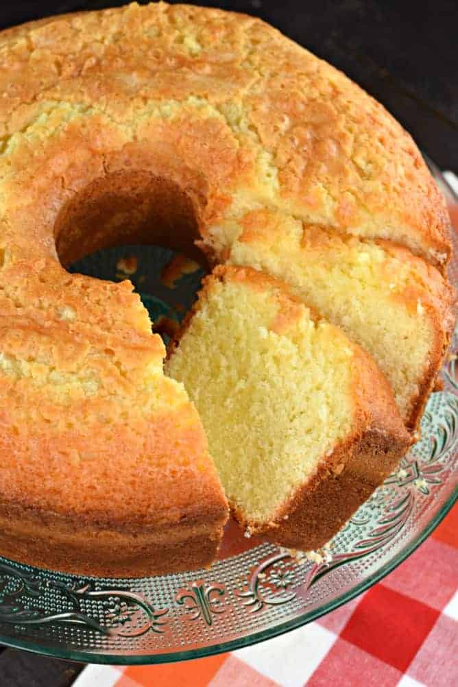 Pound cake on a glass cake plate, with two slices cut. 