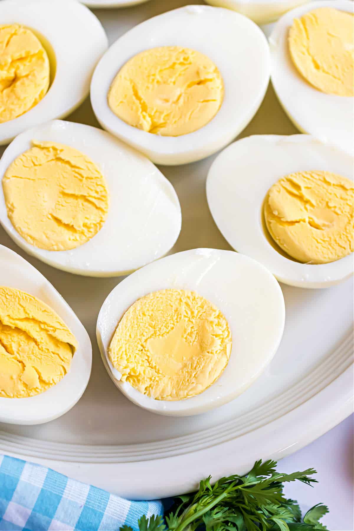 Hard boiled eggs on a white plate, cut in half.