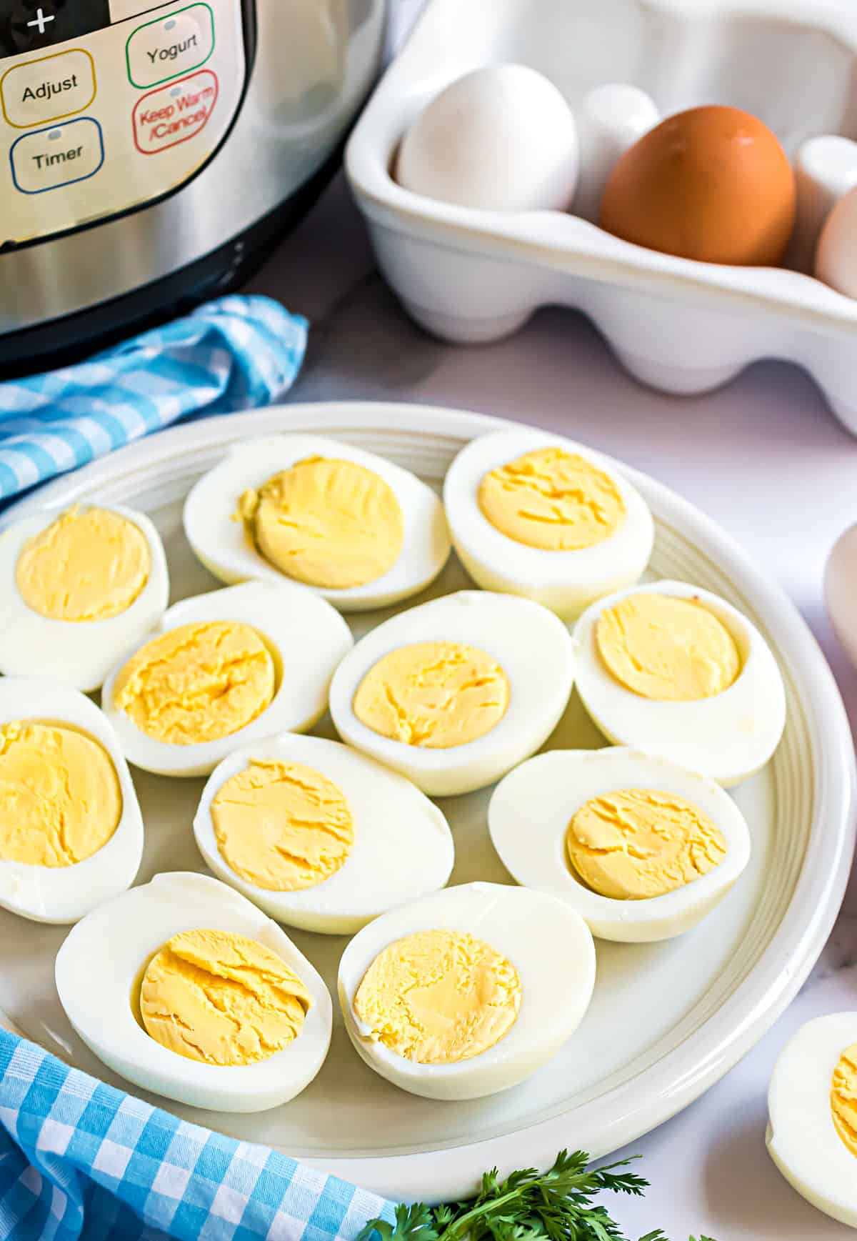 Hard boiled eggs cut in half on a white serving plate.