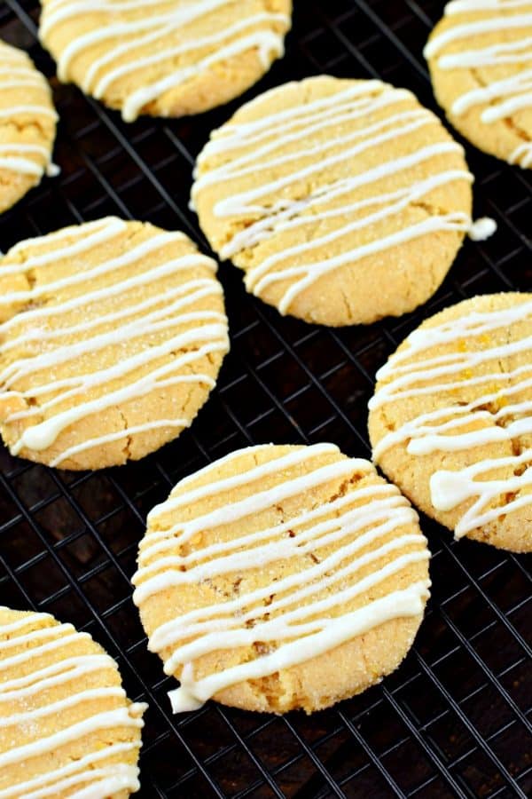 Lemon crinkle cookies with sugar and white chocolate on a wire cooling rack.