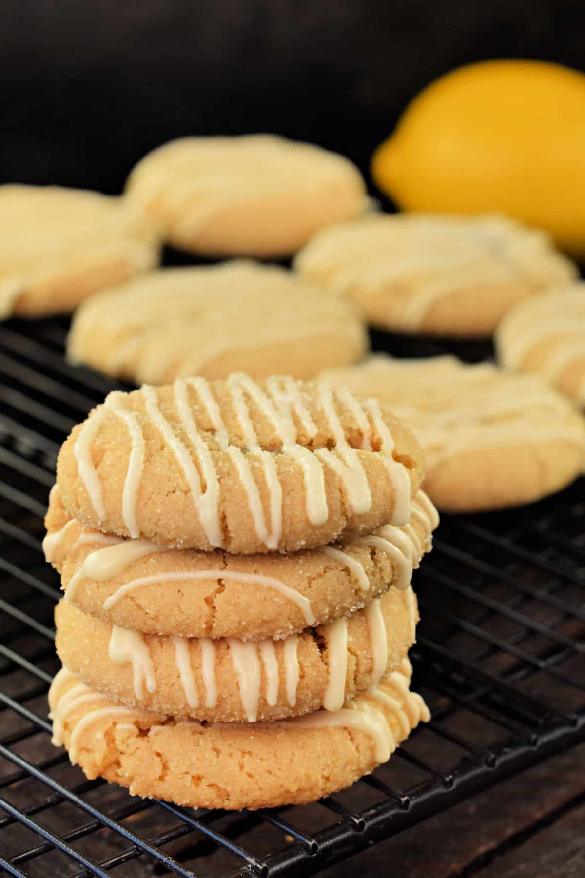 Lemon crinkle cookies stacked on a wire rack.