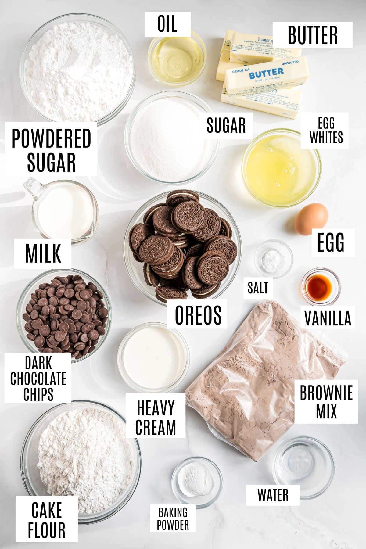 Overhead view of labeled baking ingredients for an oreo brownie cake: butter, sugar, Oreos, flour, brownie mix, eggs, milk, oil, and more.
