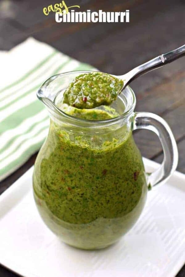 Fresh green chimichurri sauce in clear glass pitcher with spoon, vibrant, chimichurri, tex mex