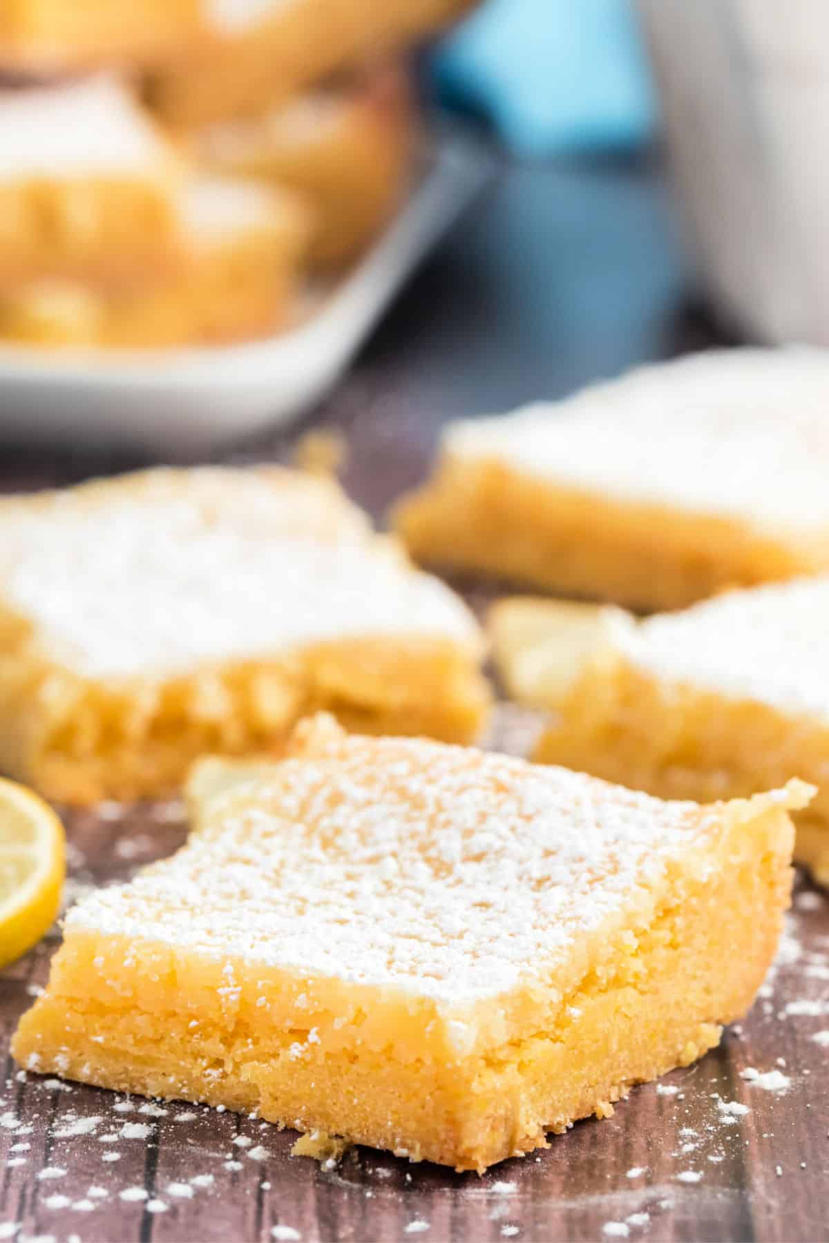 Lemon cake bars cut into squares and dusted with powdered sugar.