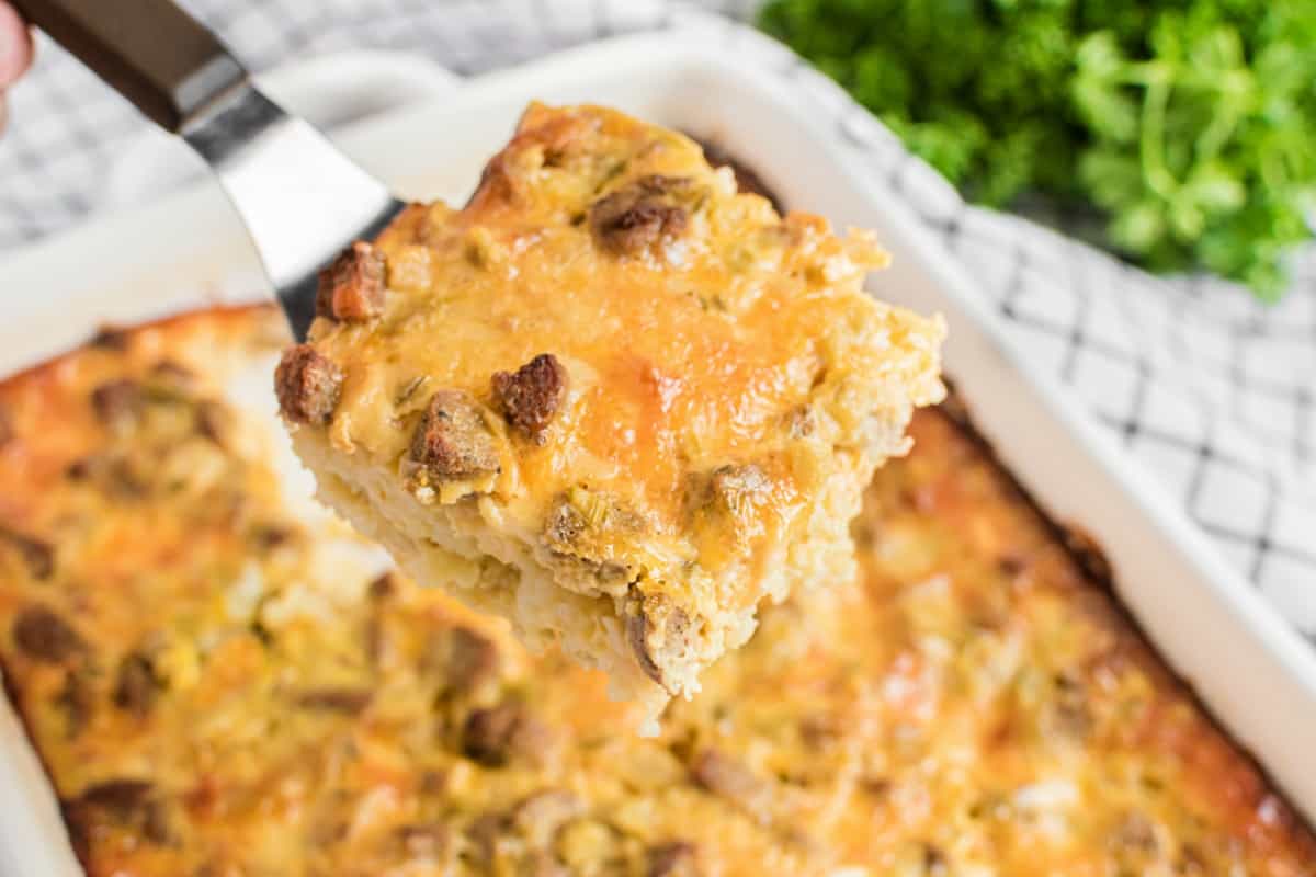 Egg casserole slice on a spatula being lifted out of pan.