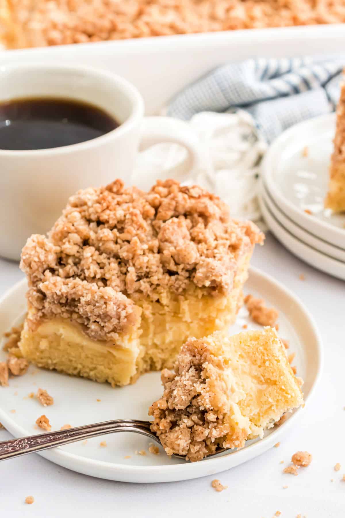 Slice of coffee cake with a fork taking a bite.