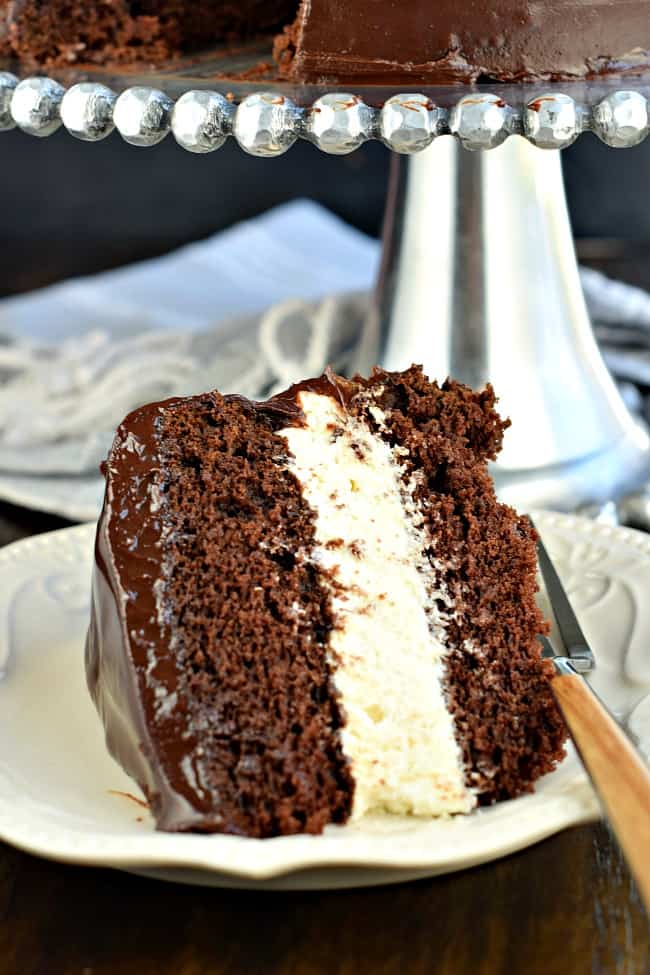 Slice of chocolate cake with cream filling and chocolate ganache.