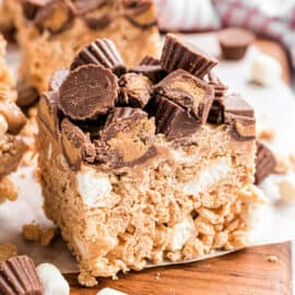 Peanut Butter Rice Krispie Treats topped with melted Reese's PB morsels and mini Reese's PB cups. A delicious twist on a childhood favorite!