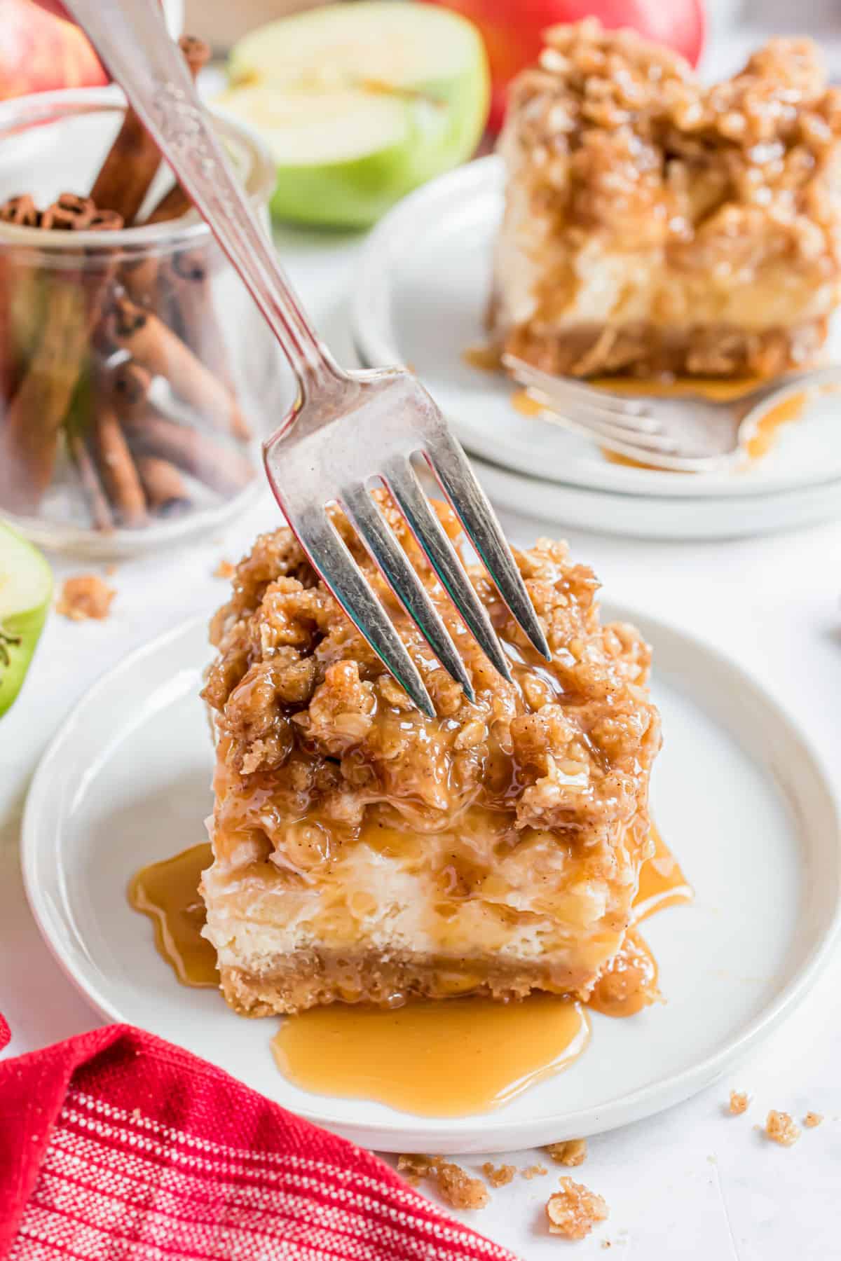 Caramel apple cheesecake bar on a plate with a fork.