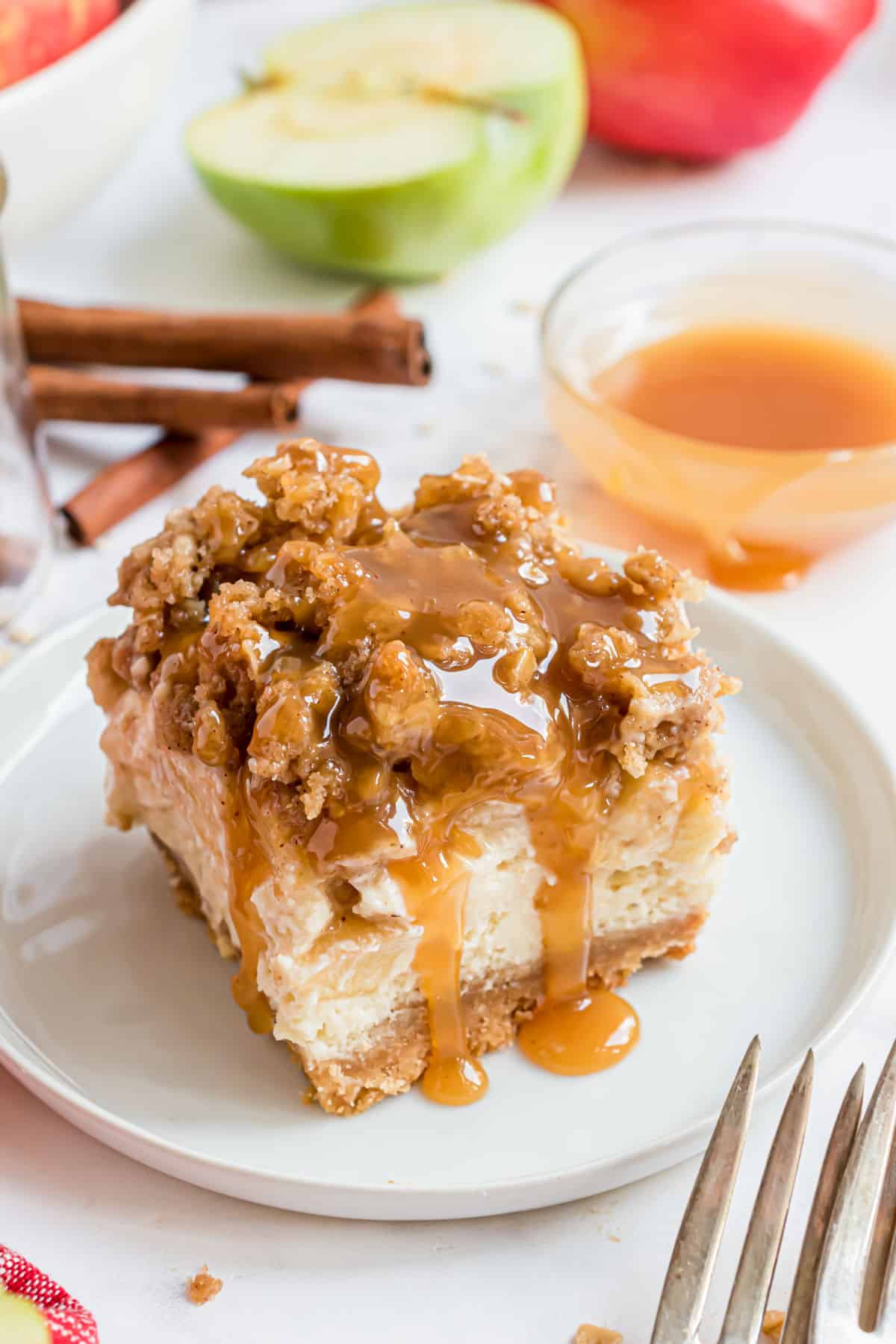 Slice of caramel apple cheesecake bar served on a white dessert plate.