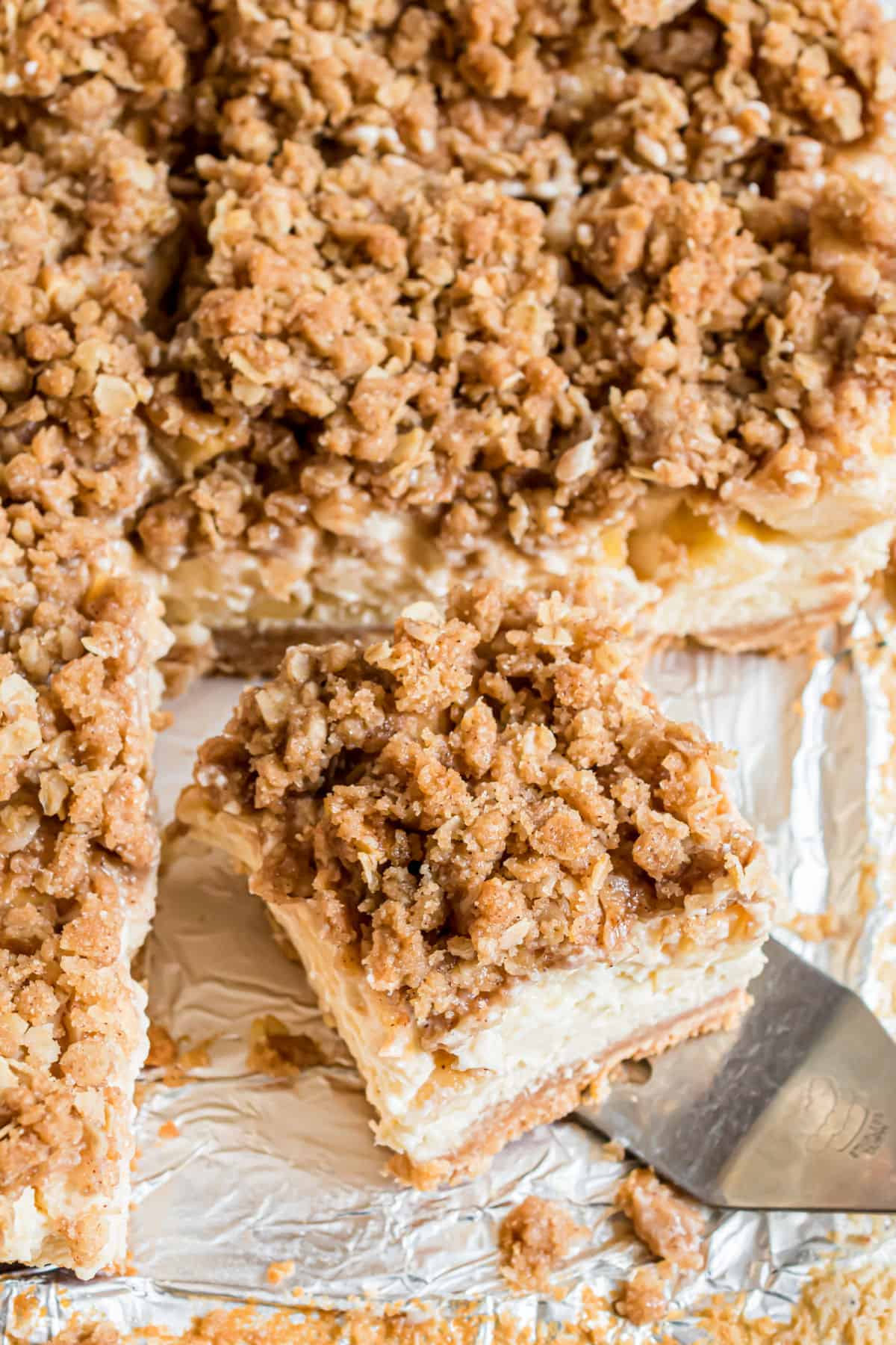 Apple cheesecake bars topped with streusel and cut into squares.