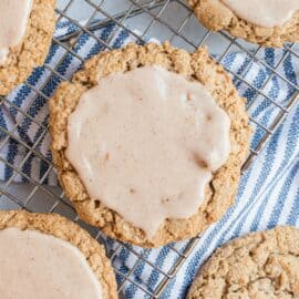 Iced oatmeal cookies on a wire rack.